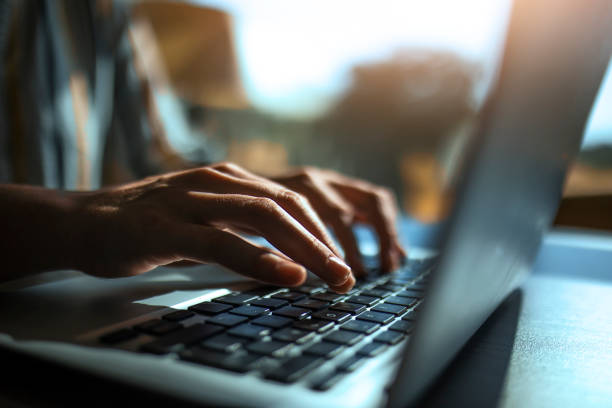 A person typing on a laptop at home, hands only visible